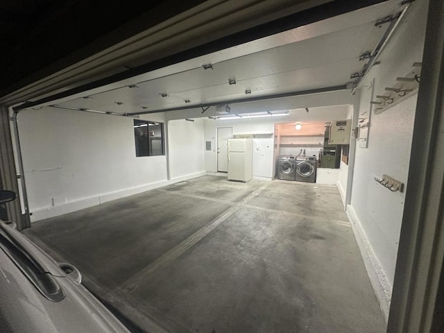 garage with washing machine and dryer and white refrigerator