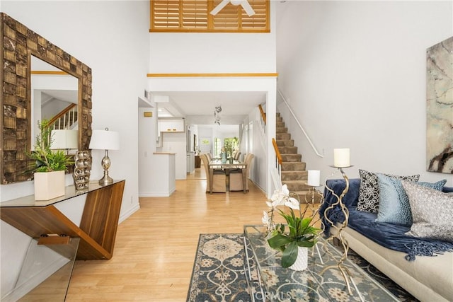 living room with a high ceiling and light wood-type flooring