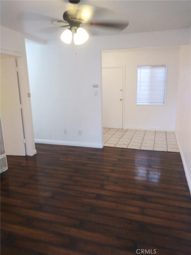 unfurnished room featuring ceiling fan and dark wood-type flooring