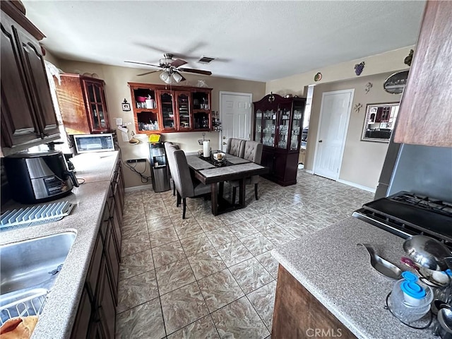 kitchen featuring ceiling fan and sink