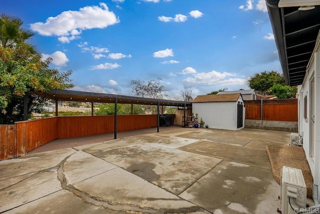 view of patio / terrace featuring a fenced backyard, a shed, and an outdoor structure