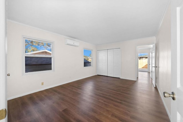 unfurnished bedroom with baseboards, ornamental molding, dark wood-style flooring, and a wall unit AC