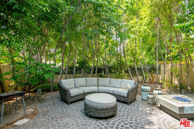 view of patio with an outdoor living space with a fire pit