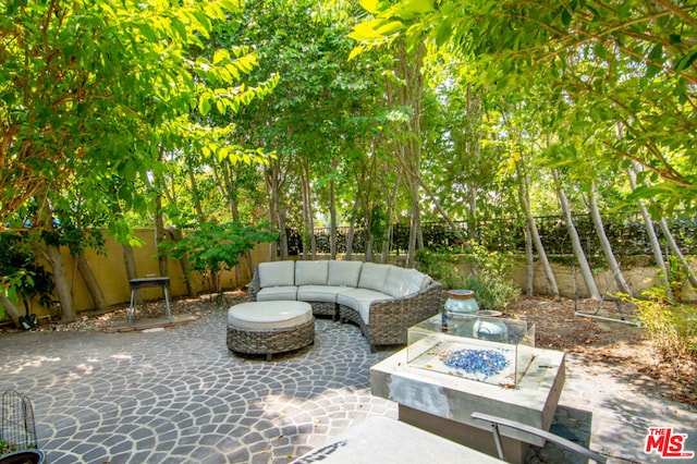 view of patio with an outdoor living space with a fire pit