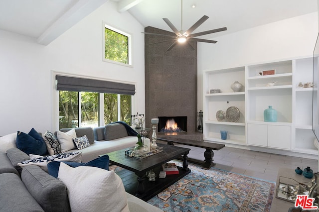 tiled living room with plenty of natural light, beam ceiling, a premium fireplace, and ceiling fan