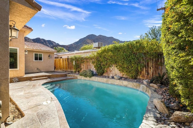 view of swimming pool with a mountain view and a patio area