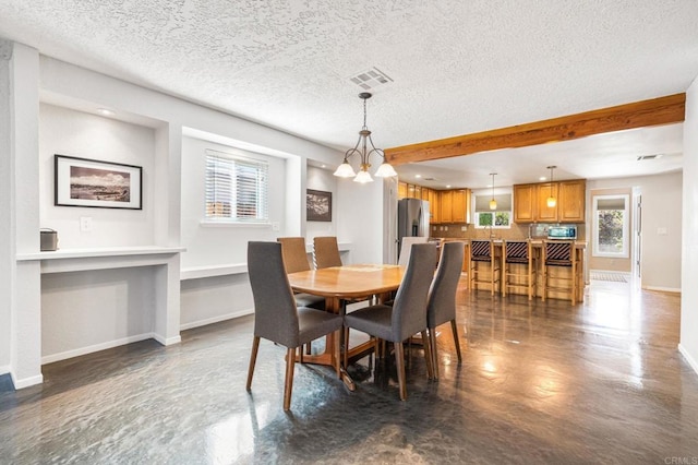 dining room featuring a textured ceiling, an inviting chandelier, and a wealth of natural light