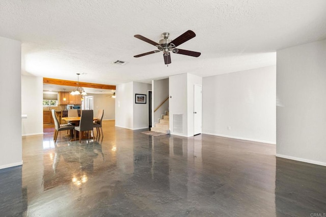 living room featuring ceiling fan with notable chandelier and a textured ceiling