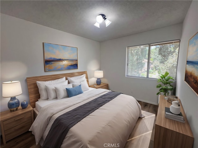 bedroom with wood-type flooring and a textured ceiling