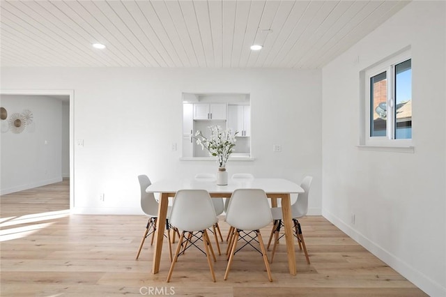 dining area with light hardwood / wood-style floors and wood ceiling