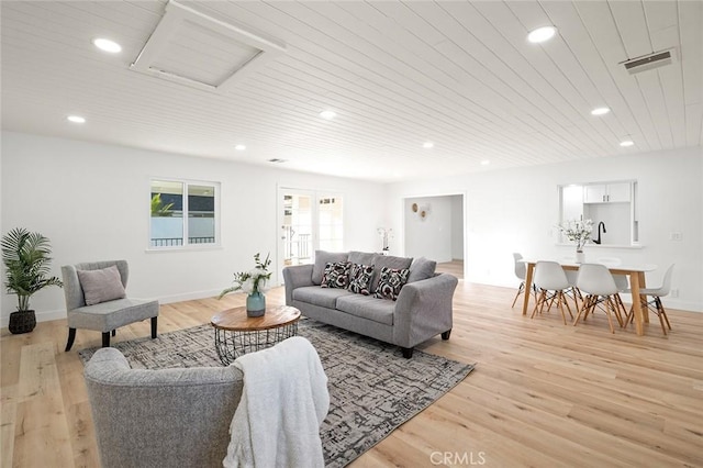 living room with light hardwood / wood-style flooring and wooden ceiling