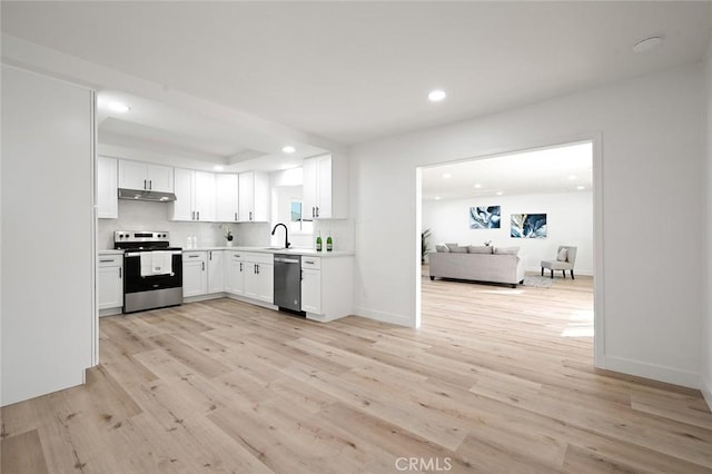 kitchen with white cabinets, sink, stainless steel appliances, and light hardwood / wood-style flooring