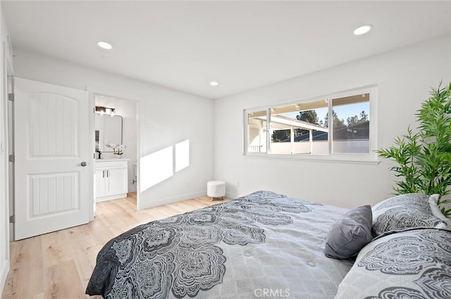 bedroom with light hardwood / wood-style flooring and ensuite bath