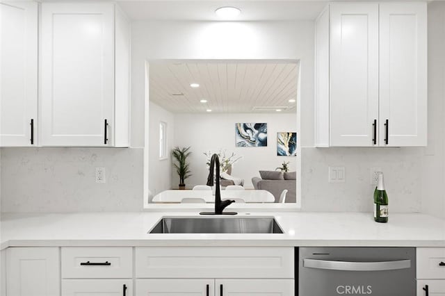 kitchen featuring white cabinets, dishwasher, and sink