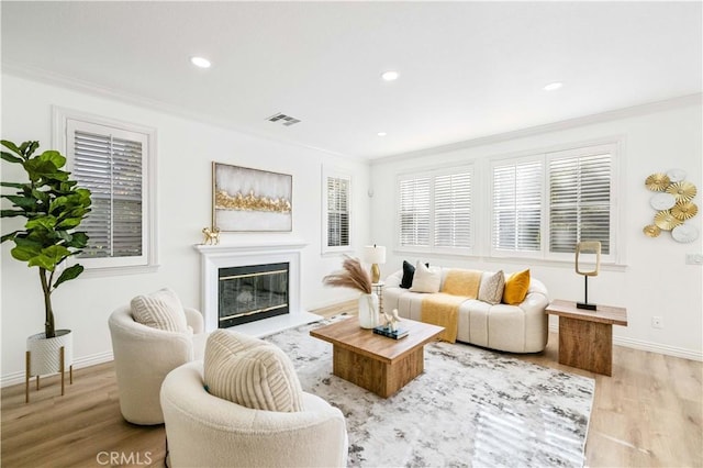 living room featuring light wood-type flooring and crown molding