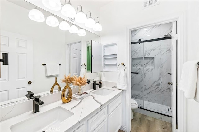 bathroom with a shower with shower door, hardwood / wood-style floors, toilet, and vanity