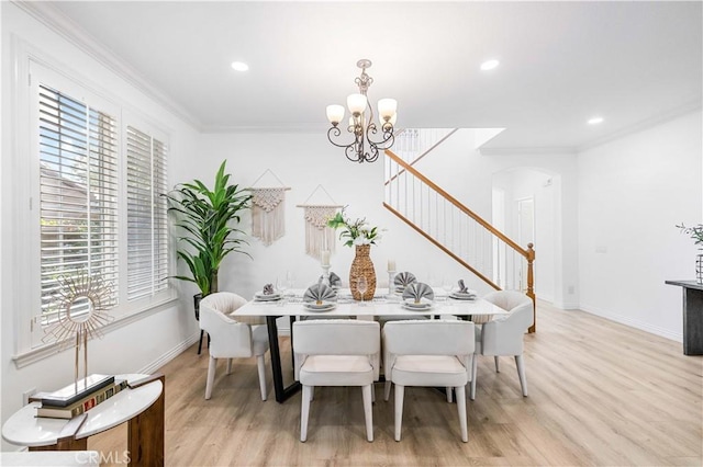 dining room featuring light hardwood / wood-style flooring, ornamental molding, and a notable chandelier