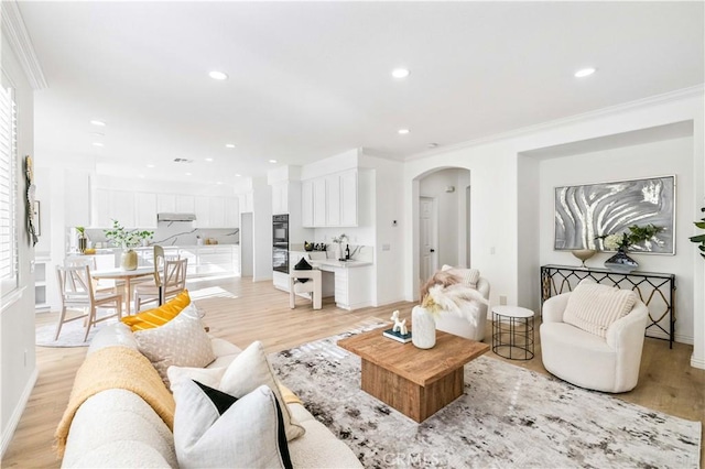 living room with light wood-type flooring and ornamental molding