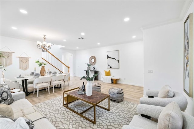 living room featuring a chandelier, crown molding, and wood-type flooring