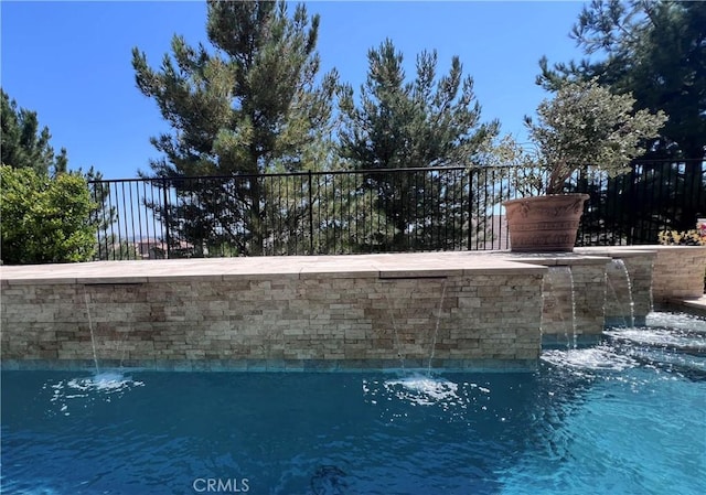 view of swimming pool with pool water feature