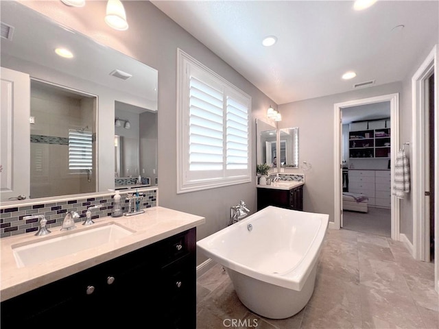 bathroom with decorative backsplash, vanity, and plus walk in shower