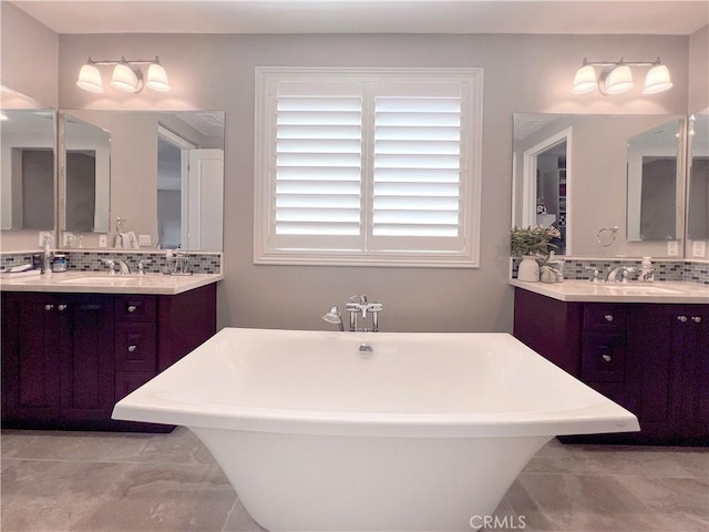 bathroom featuring a tub to relax in, vanity, tasteful backsplash, and tile patterned floors