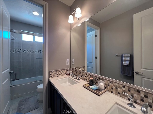 full bathroom featuring decorative backsplash, vanity, toilet, and tiled shower / bath