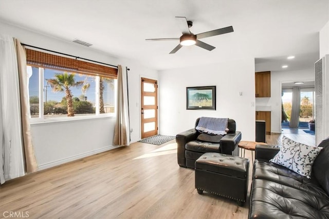 living room with light hardwood / wood-style floors, plenty of natural light, and ceiling fan