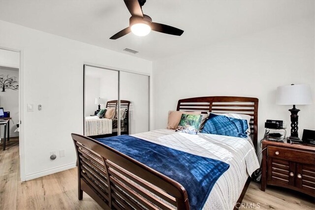 bedroom featuring ceiling fan, light wood-type flooring, and a closet