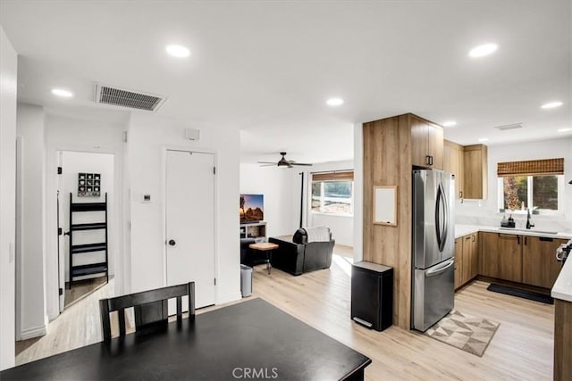 kitchen featuring stainless steel refrigerator, ceiling fan, a healthy amount of sunlight, and light wood-type flooring