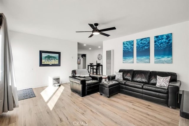 living room featuring light hardwood / wood-style floors and ceiling fan