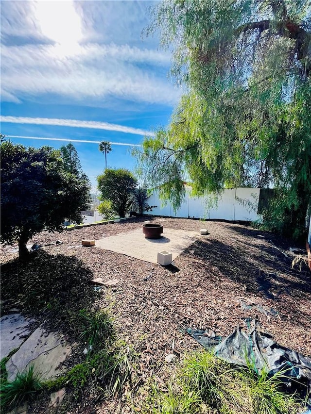 view of yard with a fire pit and fence