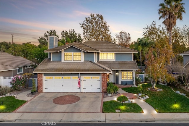 view of front of home with a garage and a lawn