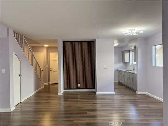 unfurnished living room featuring dark hardwood / wood-style floors and sink