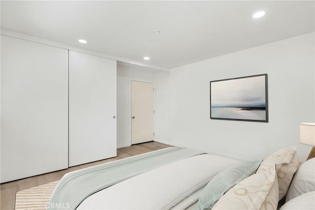 bedroom featuring light wood-type flooring and a closet