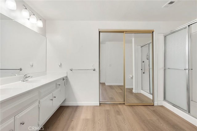 bathroom with vanity, wood-type flooring, and an enclosed shower