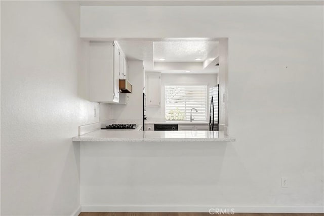 kitchen with white cabinets, sink, stainless steel fridge, a textured ceiling, and extractor fan