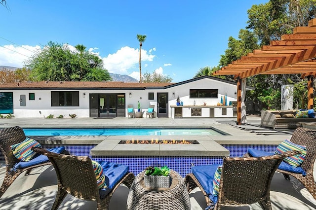 rear view of property with a patio area and a swimming pool with hot tub