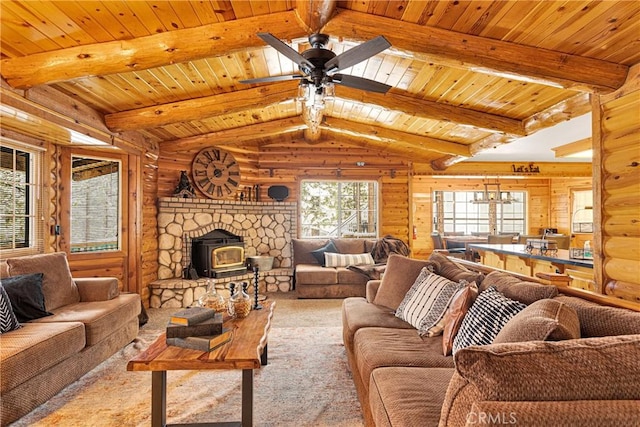 carpeted living room featuring vaulted ceiling with beams, a wood stove, ceiling fan, and wooden ceiling