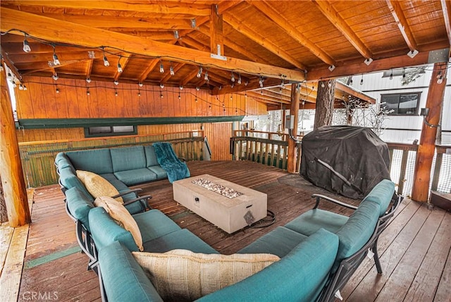 wooden deck with area for grilling and an outdoor living space with a fire pit