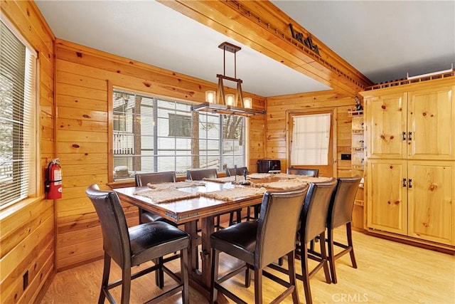 dining area featuring wooden walls and light hardwood / wood-style flooring