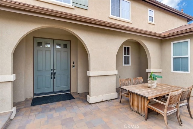 view of exterior entry featuring a patio area