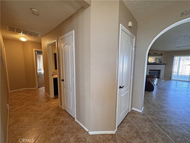 corridor with tile patterned flooring and a textured ceiling