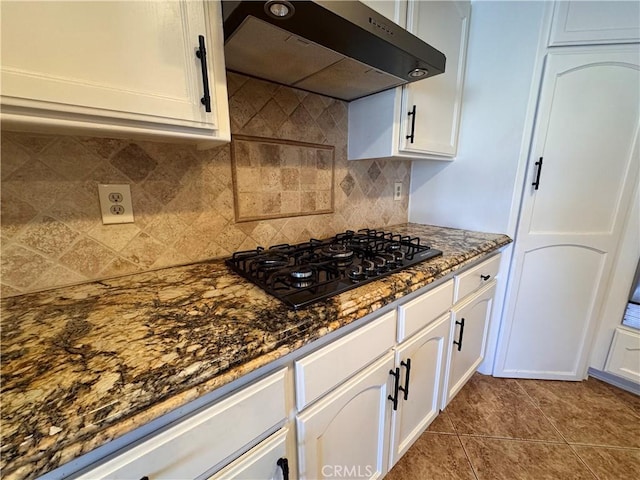 kitchen featuring white cabinets, ventilation hood, and black gas stovetop