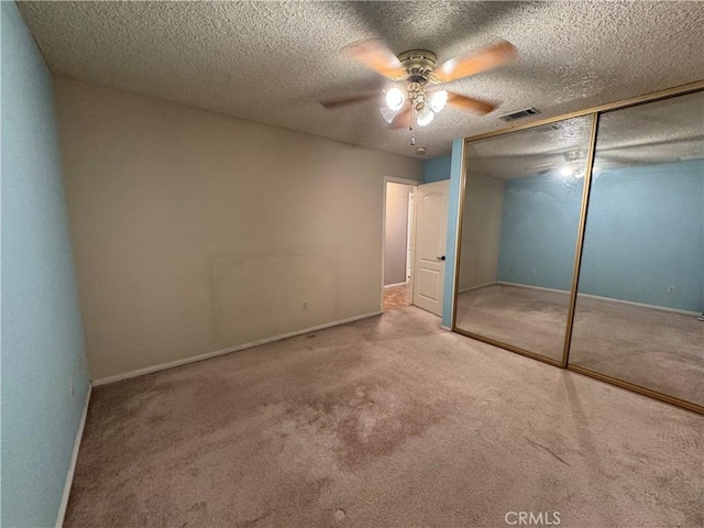 unfurnished bedroom with ceiling fan, a closet, carpet floors, and a textured ceiling