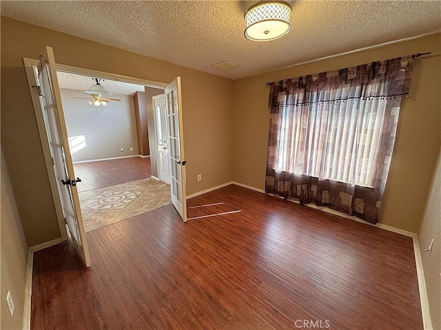 spare room with ceiling fan, wood-type flooring, and a textured ceiling