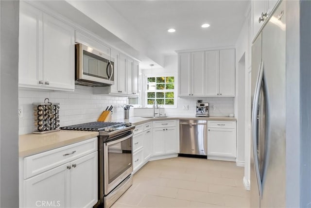 kitchen featuring backsplash, sink, white cabinets, and stainless steel appliances