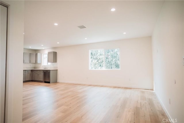 unfurnished living room featuring sink and light wood-type flooring