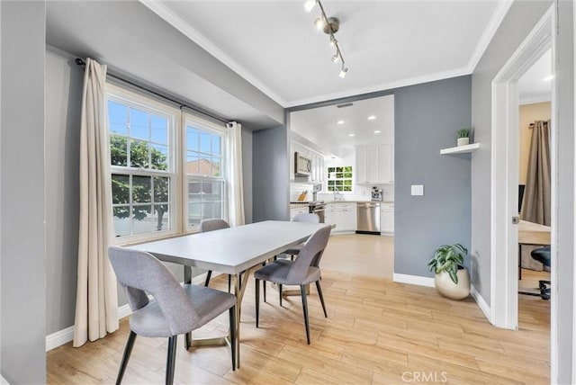 dining area with light wood-type flooring and crown molding