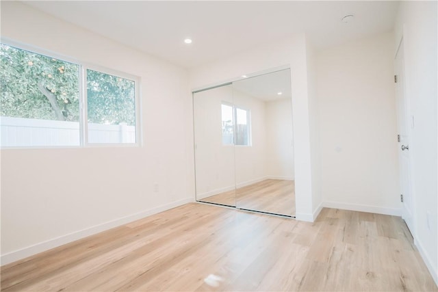 unfurnished bedroom with light hardwood / wood-style floors and a closet